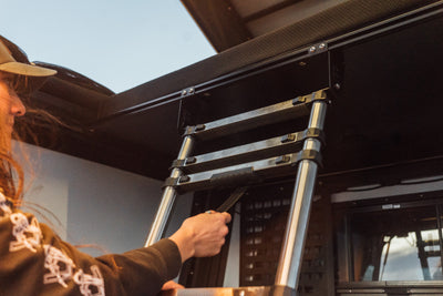 Bed Ladder — stowable truck bed access ladder that attaches to the Camper V2 front T-slot; stows under the bed when not in use, quick-deploy mechanism