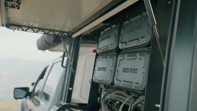 Gear Vault (with 2 tables) — external gear storage that bolts to the Lone Peak Camper V2 driver-side T-slots; 4 Gear Bags included, interior table